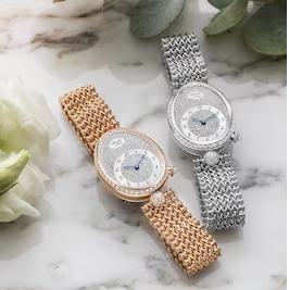 Two elegant watches on a marble surface with floral elements  | Luxe Watches Shop online